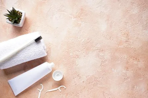 Flat lay composition of a toothbrush with a white towel and toothpaste on a b Stock Photos