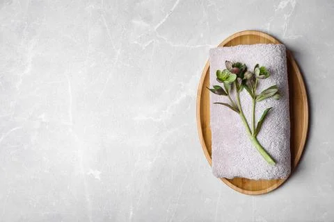 Flat lay composition with towel, flowers and space for text on light backgrou Stock-Fotos