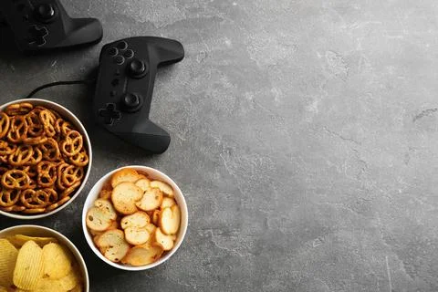 Flat lay composition with video game controller, snacks and space for text on Stock Photos
