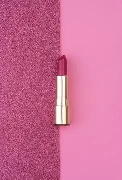 Flat lay composition with vivid pink golden lipsticks on bright pink and Stock Photos