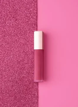 Flat lay composition with vivid pink golden lip gloss on bright pink and Stock Photos