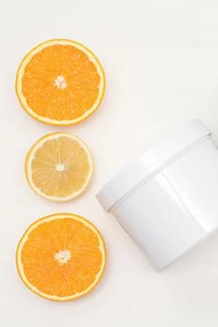 Flat lay composition of white jar with orange slices on white background Stock Photos