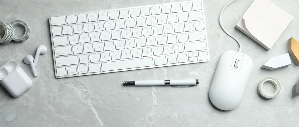 Flat lay composition with wired computer mouse and keyboard on light grey m.. Stock Photos