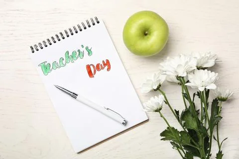 Flat lay composition with words TEACHER'S DAY, flowers and apple on white woo Foto stock