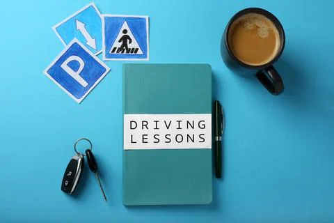 Flat lay composition with workbook for driving lessons on light blue backgrou Stock Photos