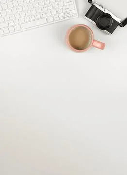 Flat lay of computer keyboard, digital camera and a cup of coffee on white ba Stock Photos