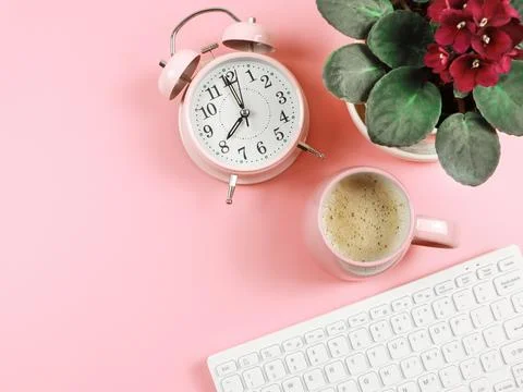 Flat lay of computer keyboard, pink coffee cup, pink vintage alarm clock an.. Stock Photos