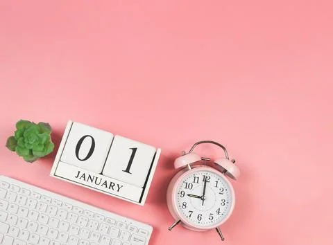 Flat lay of computer keyboard, wooden calendar 01 January, pink vintage alarm Stock Photos