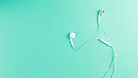 Flat lay concept: headphone on Mint backgrounds. White headphones on a Mint b Stock Photos