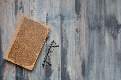 Flat lay of covered ancient book and glasses on vintage hoary background. Cop Stock Photos