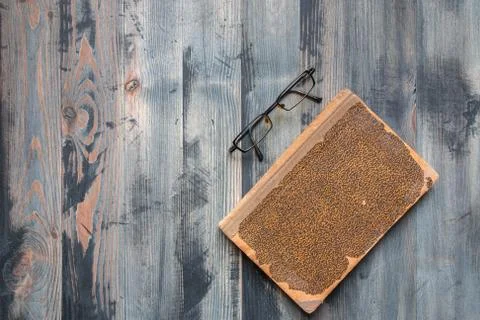 Flat lay of covered ancient book and glasses on vintage hoary background. Cop Stock Photos