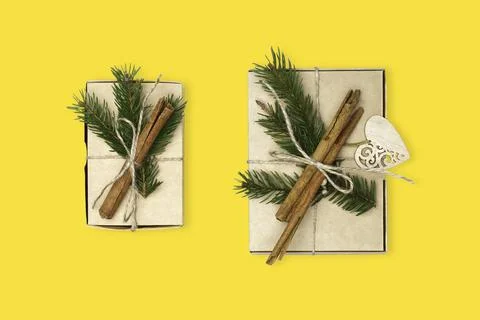 Flat lay craft boxes with pine tree, rope and cinnamon on yellow background Stock Photos