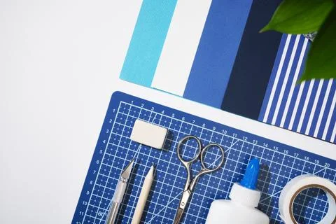 Flat lay of craft tools on a blue cutting mat. Creative workspace with scisso Foto stock