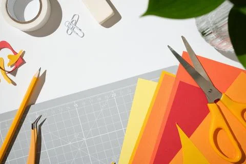 Flat lay of creative hobby tools with a gray cutting mat, orange scissors, .. Stock Photos
