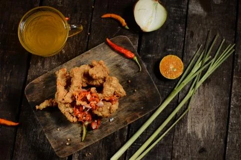 Flat lay Crispy fried chicken pieces and Balinese sambal matah with a glass o Stock Photos