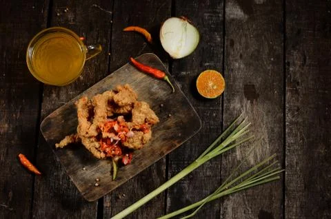 Flat lay Crispy fried chicken pieces and Balinese sambal matah with a glass o Stock Photos