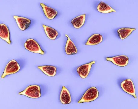 Flat lay of cut figs on a blue background. Copy space. Stock Photos