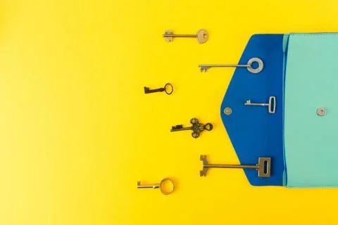 Flat lay of cute bag open out with a lot of old keys on colorful background w Stock Photos