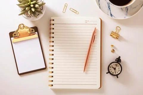 Flat lay desk with notebook, clipboard, clock, plant and pen, golden accessor Stock Photos