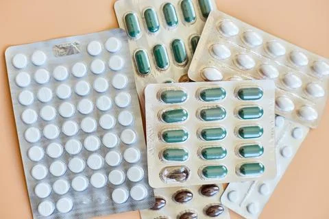 Flat lay different blister pack of Medical pills on orange background Stock Photos