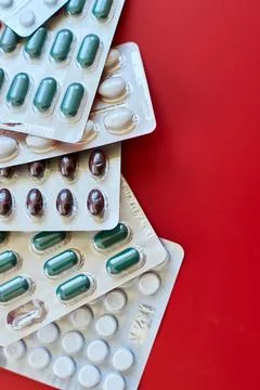 Flat lay different blister pack of Medical pills on red background Stock Photos