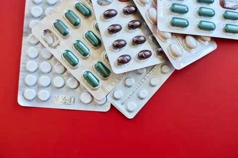Flat lay different blister pack of Medical pills on red background Stock Photos