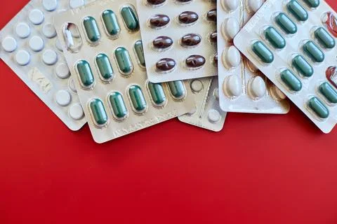 Flat lay different blister pack of Medical pills on red background Stock Photos