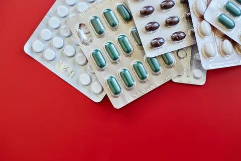 Flat lay different blister pack of Medical pills on red background Stock Photos