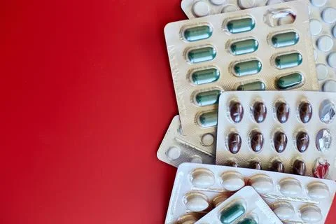 Flat lay different blister pack of Medical pills on red background Stock Photos