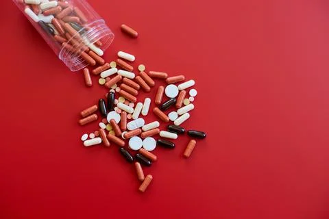 Flat lay different colorful Medical pills on red background Stock Photos
