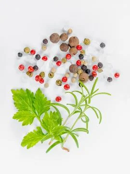 Flat lay of different peppers, greenery and sea salt on white background, clo Stock Photos