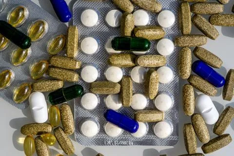 Flat lay of different pills and capsules are on the table from virus. Stock Photos