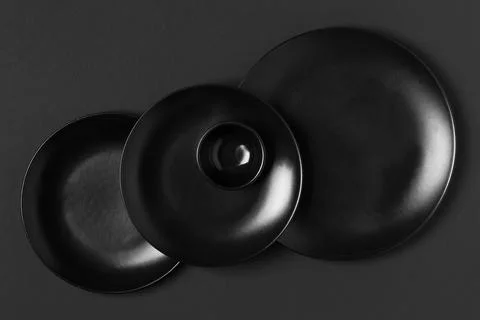 Flat lay different sized black plates arrangement Stock Photos