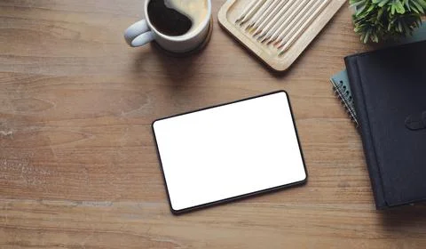 Flat lay digital tablet with blank screen, books, coffee cup and potted plant Stock Photos