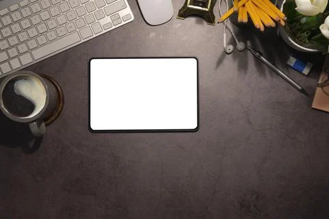 Flat lay digital tablet with blank screen, coffee cup and stationery on black Stock Photos