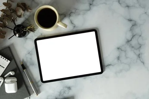 Flat lay digital tablet with empty screen, coffee cup and supplies on marble  Stock Photos