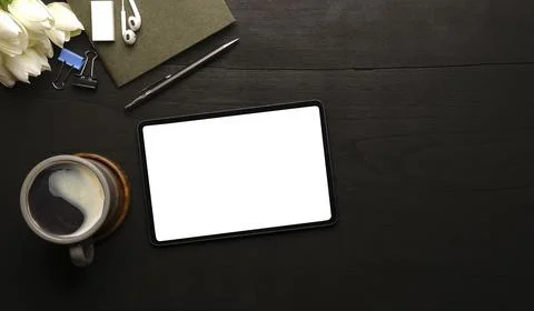 Flat lay digital tablet with empty screen, coffee cup and supplies on wood ba Stock Photos