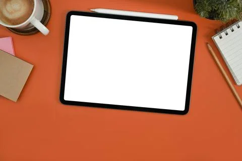Flat lay digital tablet with white empty screen, notepad, coffee cup and potted Stock Photos