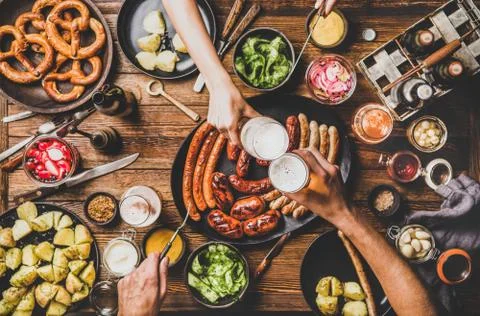 Flat-lay of dinner table with beer, Bavarian sausages and snacks Stock Photos