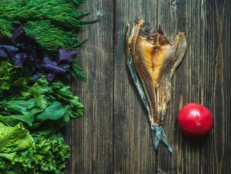 Flat lay dried open cut fish with tomato and fresh herbs Stock Photos