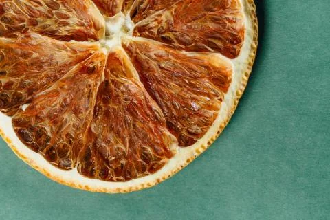 Flat lay dried orange texture slice with turquoise paper grunge background Stock Photos