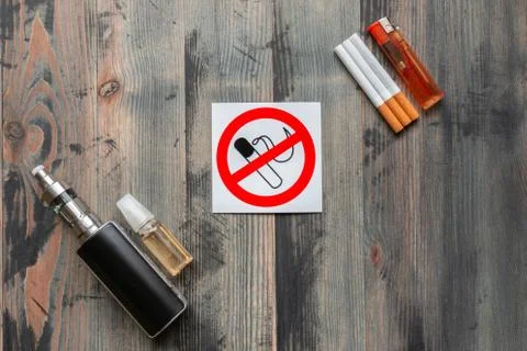 Flat lay of e-cigarette, e-liquid, tobacco cigarettes with lighter and sign s Stock Photos