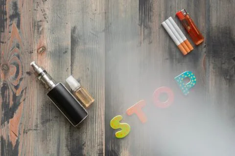 Flat lay of e-cigarette, e-liquid, tobacco cigarettes with lighter and letter Stock Photos