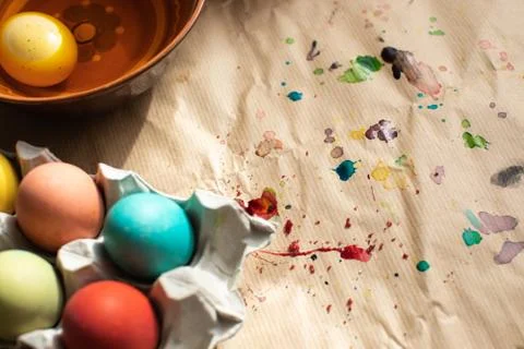 Flat lay Easter background.  Colorful Easter eggs and spilled paint. Space fo Stock Photos