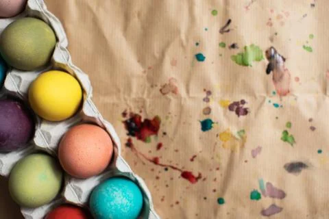 Flat lay Easter background.  Colorful Easter eggs and spilled paint. Space fo Stock Photos