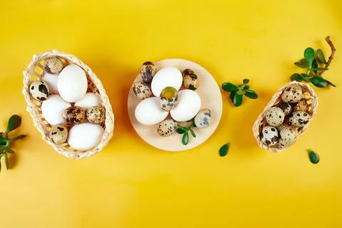 Flat lay easter composition with green leaves and easter eggs on a yellow bac Foto stock