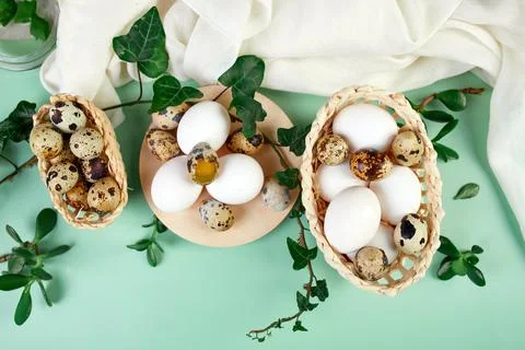 Flat lay easter composition with green leaves and easter eggs on a yellow bac Stock Photos