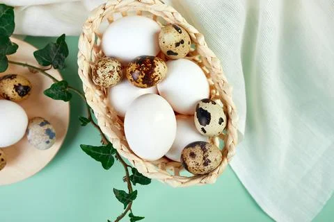 Flat lay easter composition with green leaves and easter eggs on a yellow bac Stock Photos