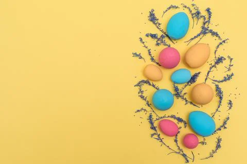 Flat lay Easter pastel colored eggs on yellow background Stock Photos