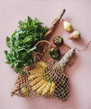 Flat-lay of eco-friendly bag with fresh ingredients over pink background Stock Photos